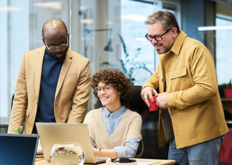 Three colleagues organising a plan together at a desk