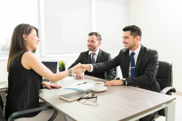 Two executives reviewing transaction documents across a table